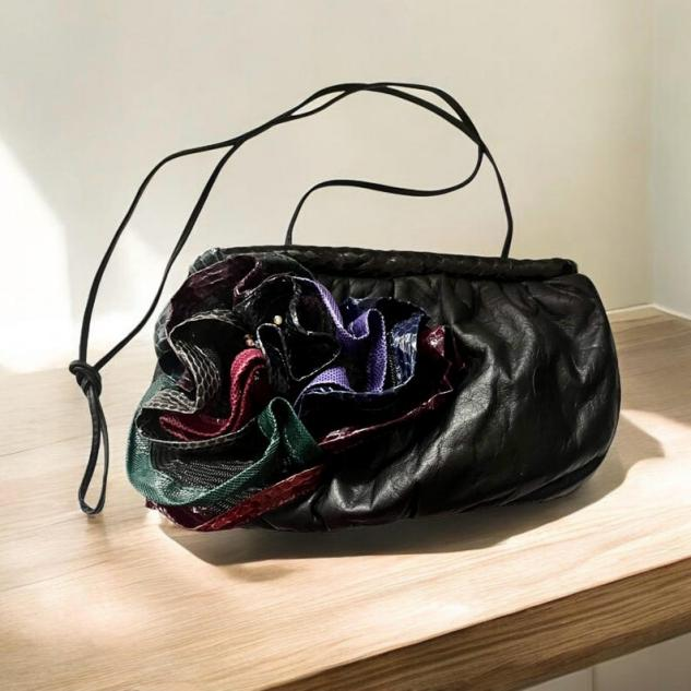 Avant-garde black leather handbag with colorful textured floral applique, 1980s fashion statement