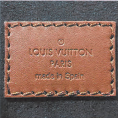 Spotting Fake Designer Bags-Square leather tag from a Louis Vuitton bag, featuring "LOUIS VUITTON PARIS" and "made in Spain" embossing.