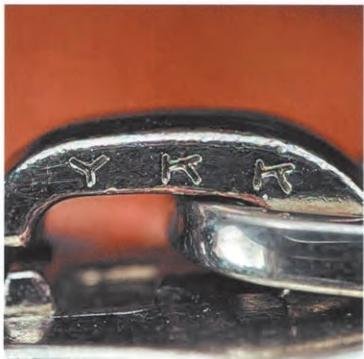 Spotting Fake Designer Bags-Close - up of a YKK zipper head, with the "YKK" logo clearly engraved.
