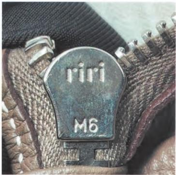 Spotting Fake Designer Bags-Close - up of a riri zipper head, embossed with "riri" and "M6".