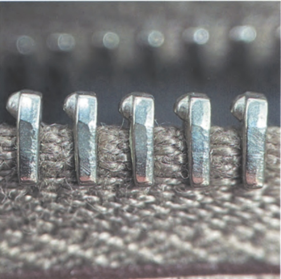 Detail of authentic Riri zipper on Hermès Kelly bag, showing smooth teeth and precise metal pull tab.