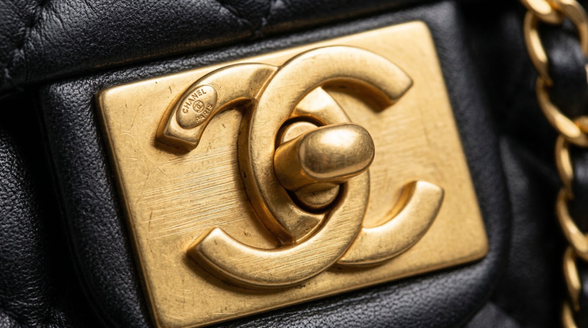 Authentic Chanel flathead screw on a metal clasp backplate used to Chanel Authentication.