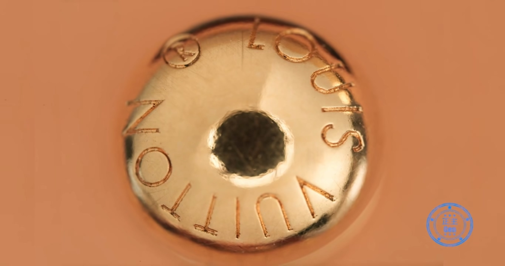 Macro close-up of authentic Louis Vuitton strap buckle back showing the specific gear shape with exactly 12 teeth carved into the base, a key authentication feature of genuine hardware.