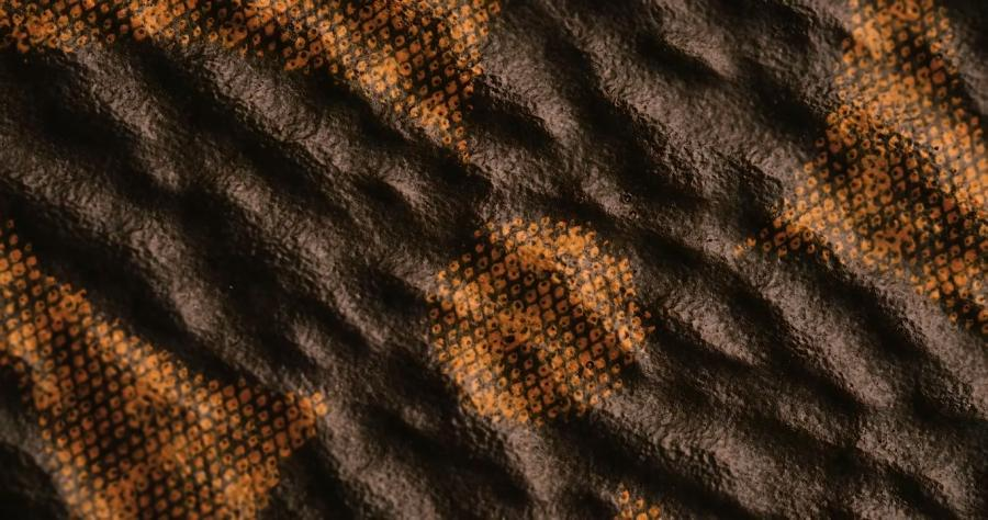 Extreme macro close-up of authentic Louis Vuitton Monogram canvas showing the yellow dot matrix pattern, where four small vertical diamond-shaped dots form larger vertical diamonds with some hollow black centers, displaying organic ink blurring on diagonal staircase gradients.
