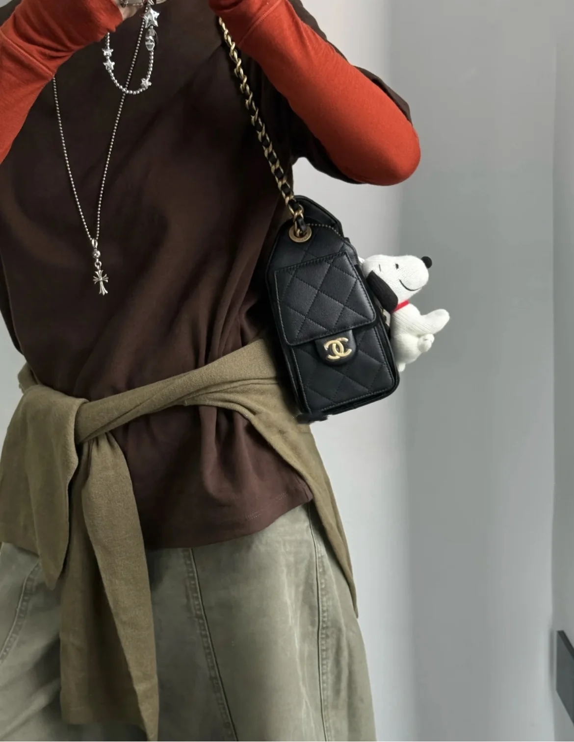 Side styling view of a black Chanel 25 Mini replica with quilted pocket