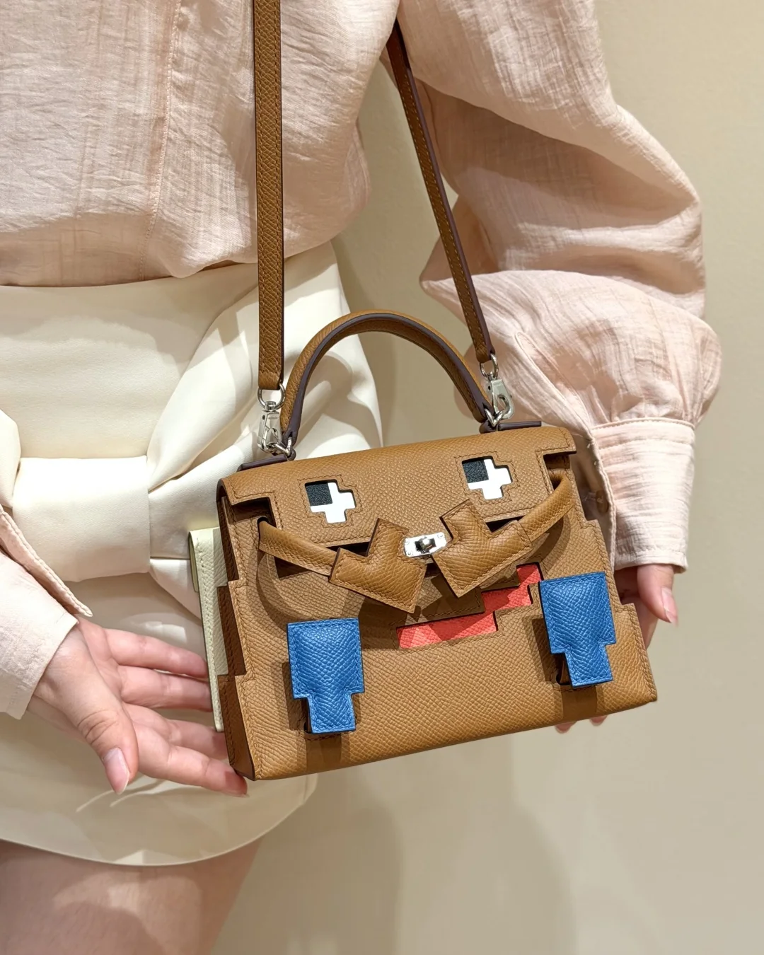Close front styling view of a Gold Kellydoll Picto replica hanging at the hip