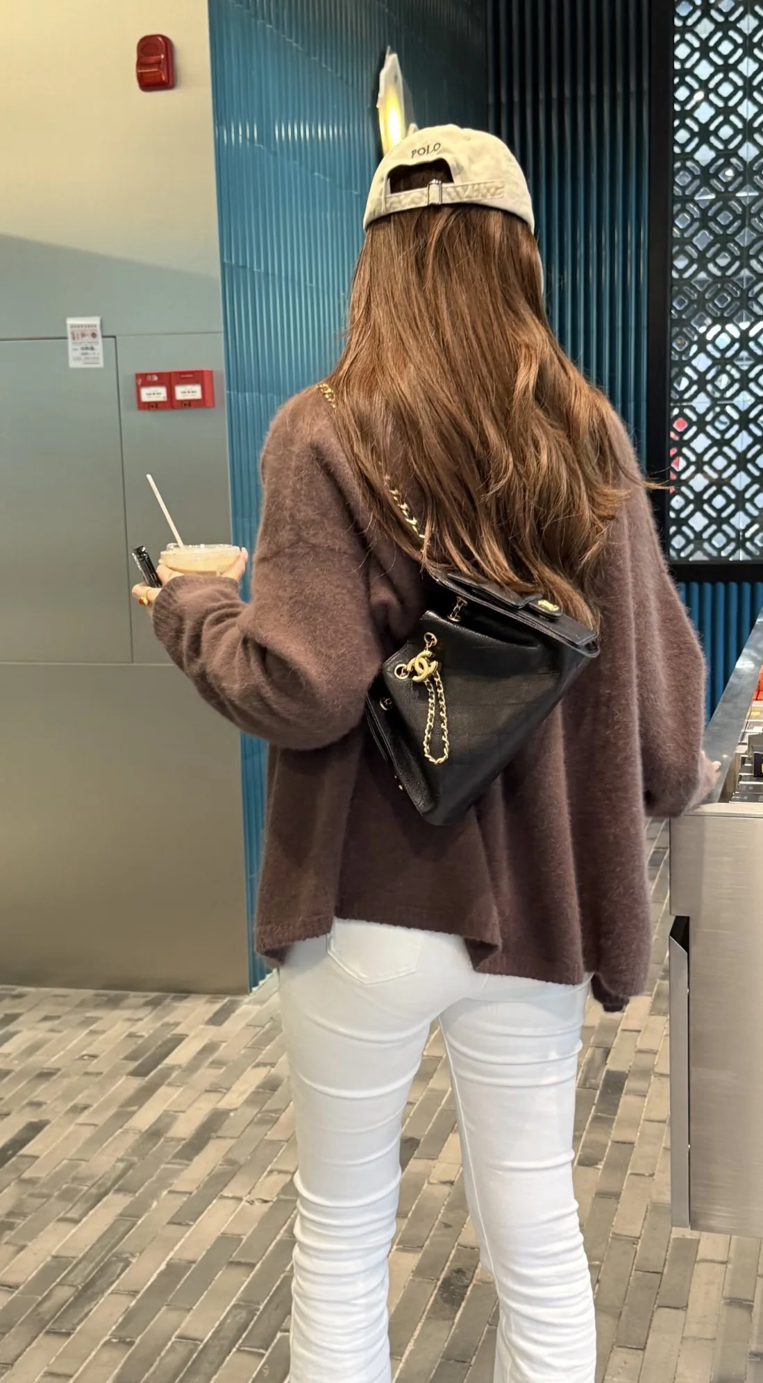 Rear crossbody styling view of a black Chanel 25 Mini bag