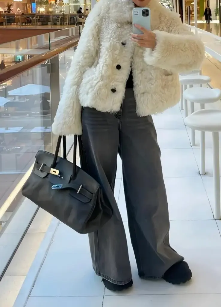 Mirror styling view of a black Shoulder Birkin 42 replica carried at hip level