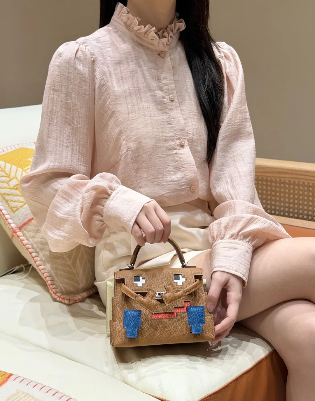 Seated styling view with the small character bag resting on the lap