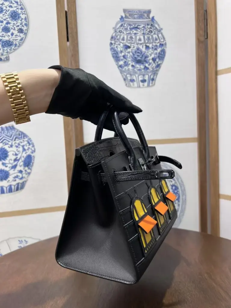 Close side view of the structured Birkin 20 Faubourg replica and dark straps