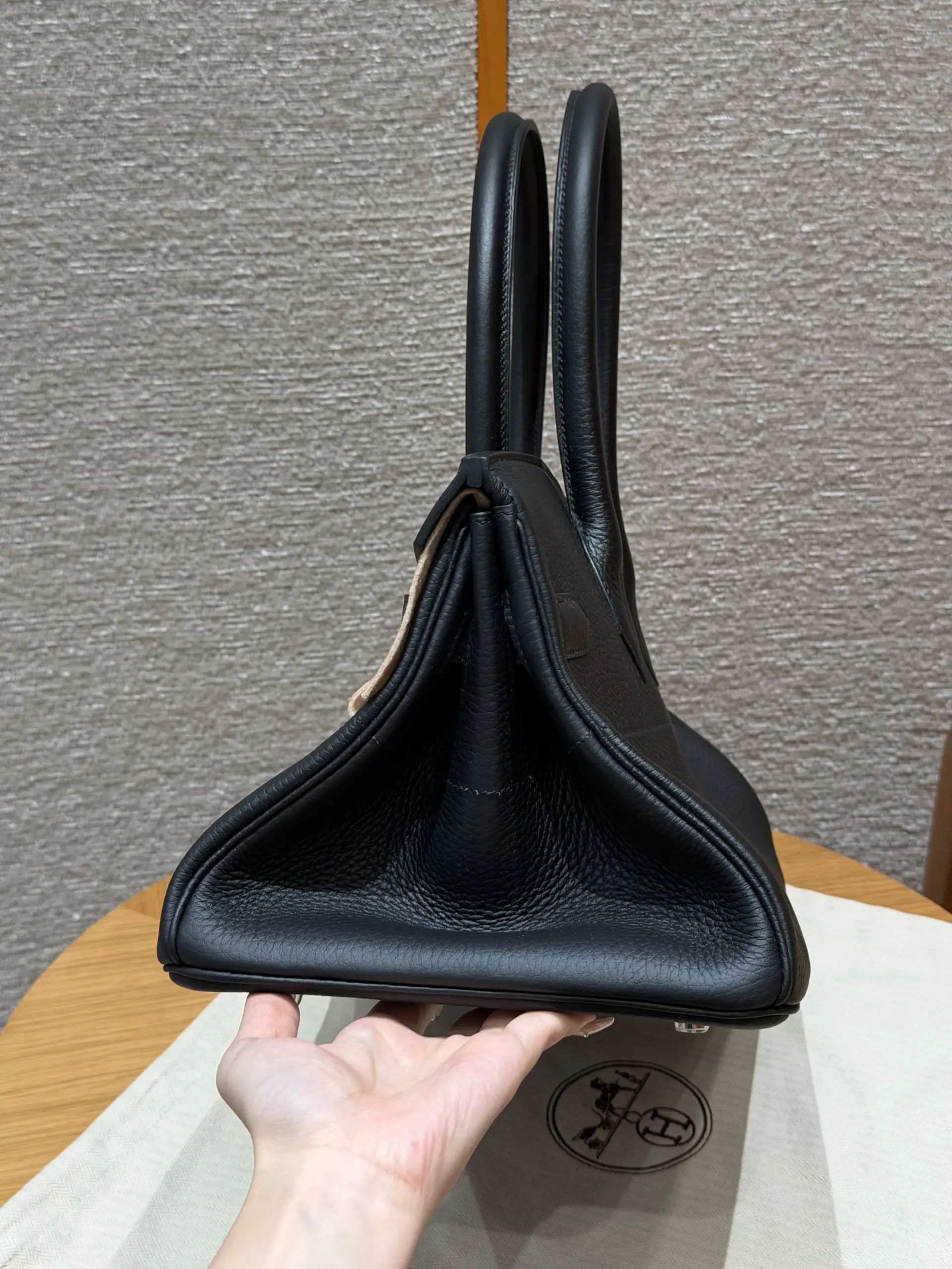 Side profile of a black Shoulder Birkin 42 replica showing its deep gusset and soft folds