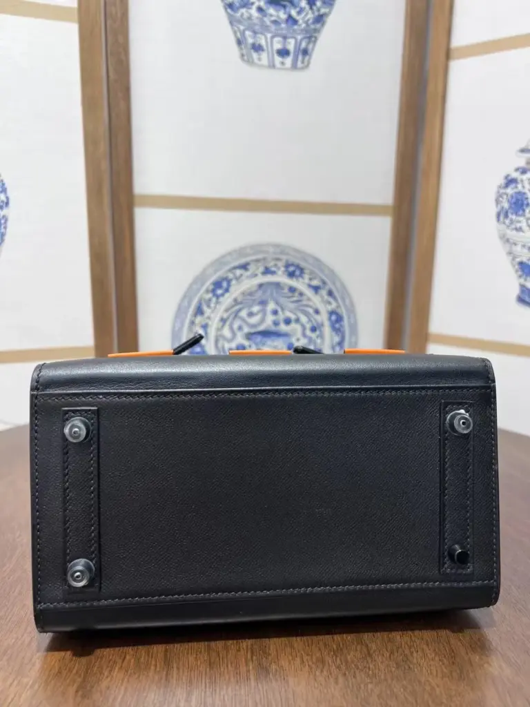 Base of a Birkin 20 Faubourg replica showing four feet and two reinforcement strips
