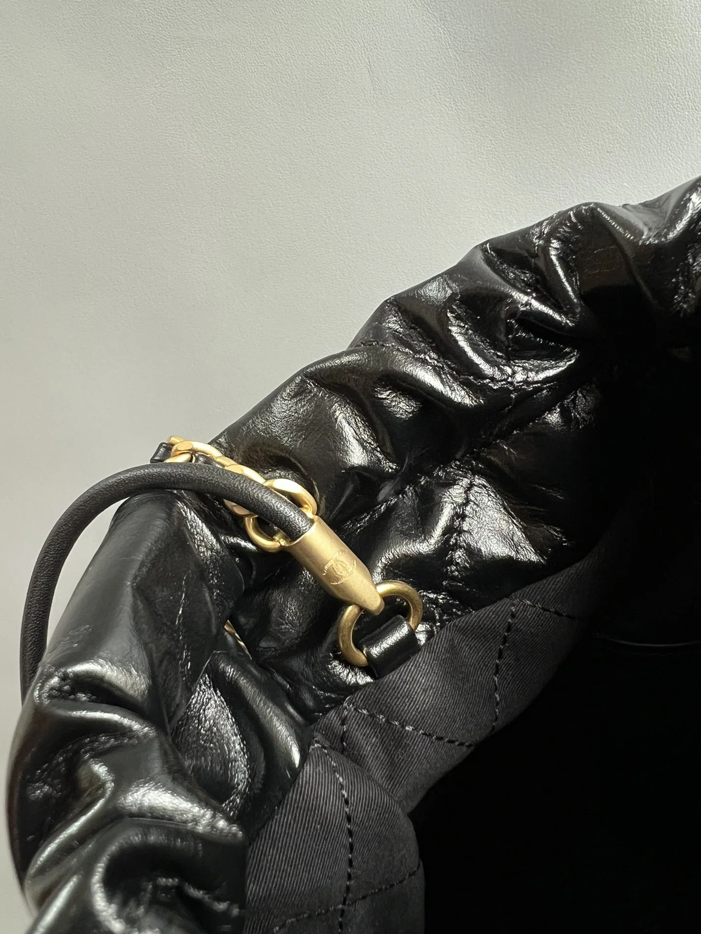 Gold-tone drawstring connector and black lining close-up