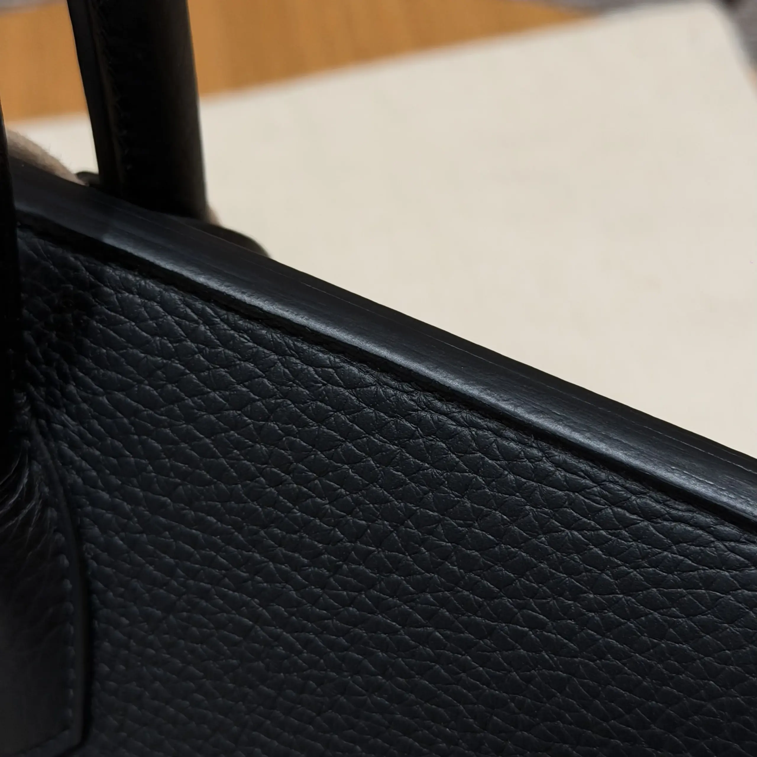 Macro view of the pebbled black leather and rounded upper edge on a Shoulder Birkin 42 replica