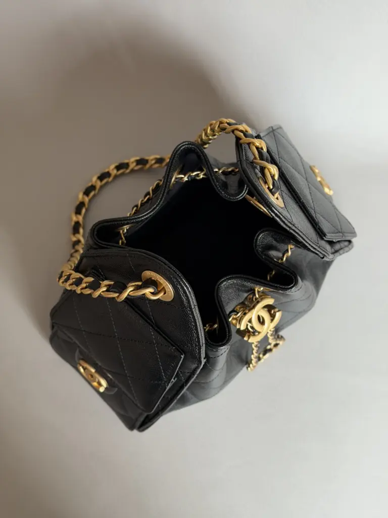 Open interior view of a black Chanel 25 Mini-style drawstring bag