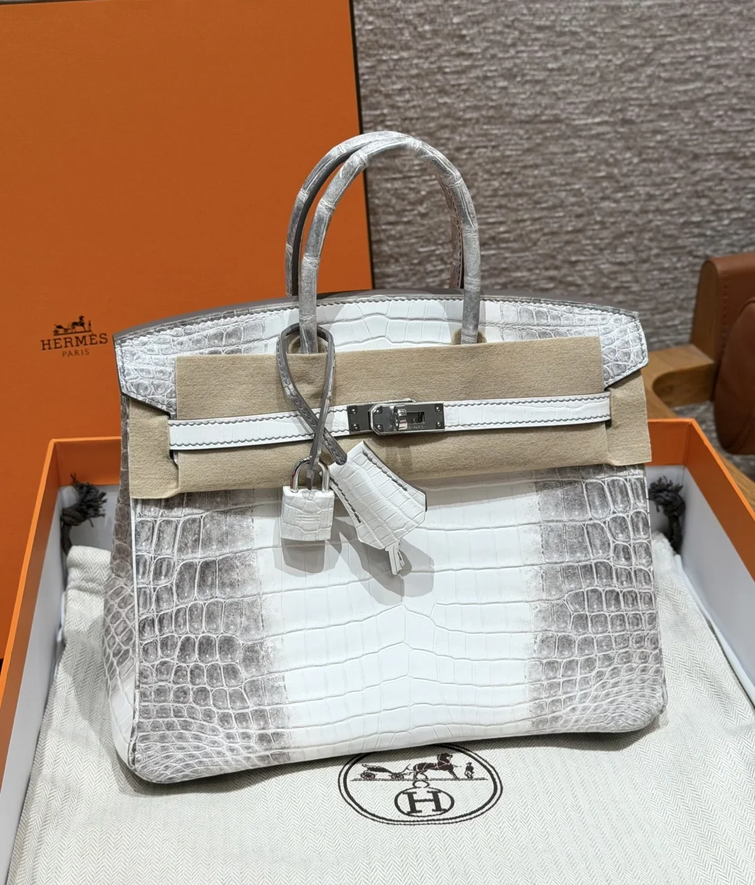 Straight-on Kelly 25 Himalaya replica in an orange presentation box