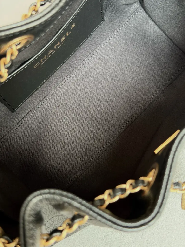 Close interior view with dark lining, stitched pocket and brand patch