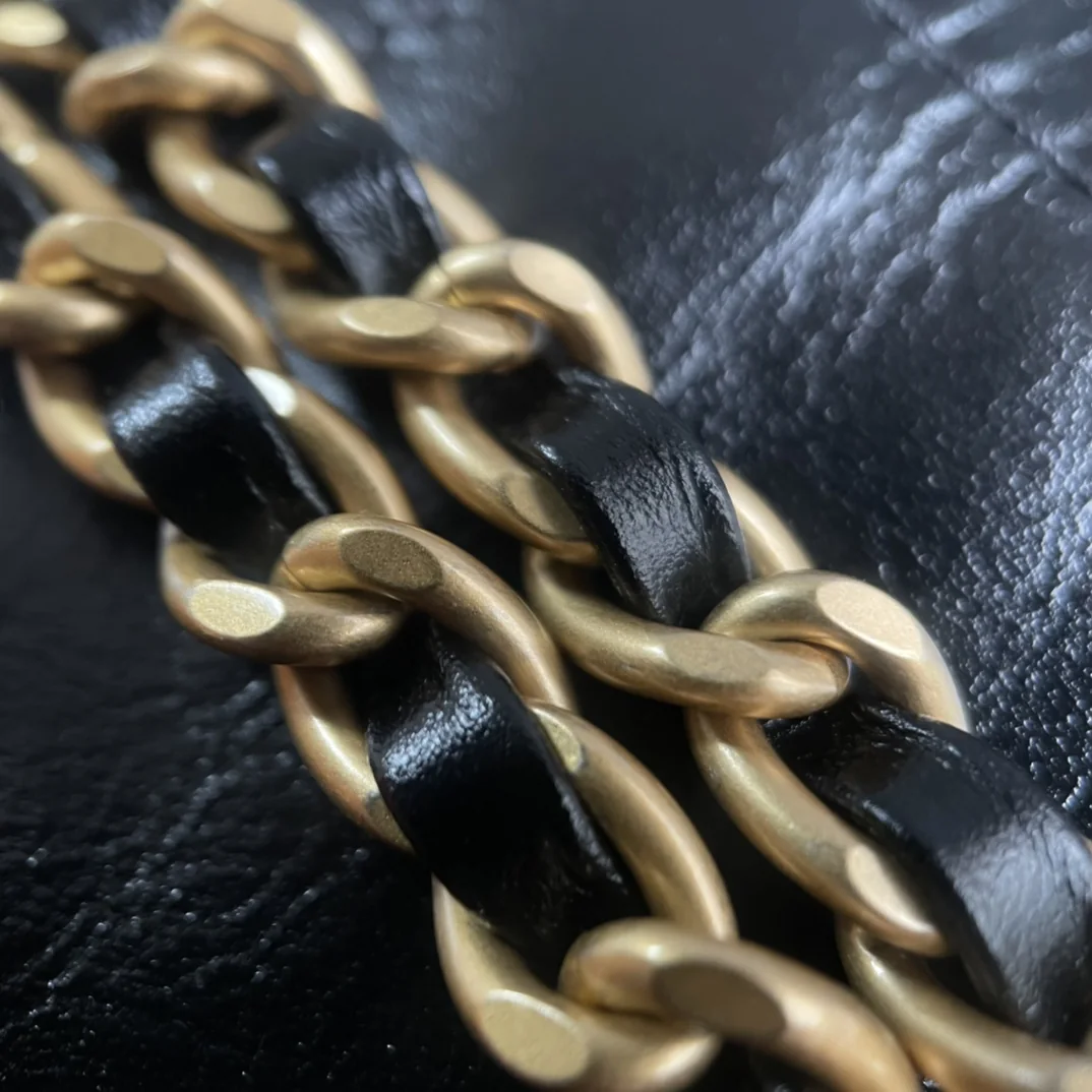 Macro of leather-interlaced aged-gold-tone chain links