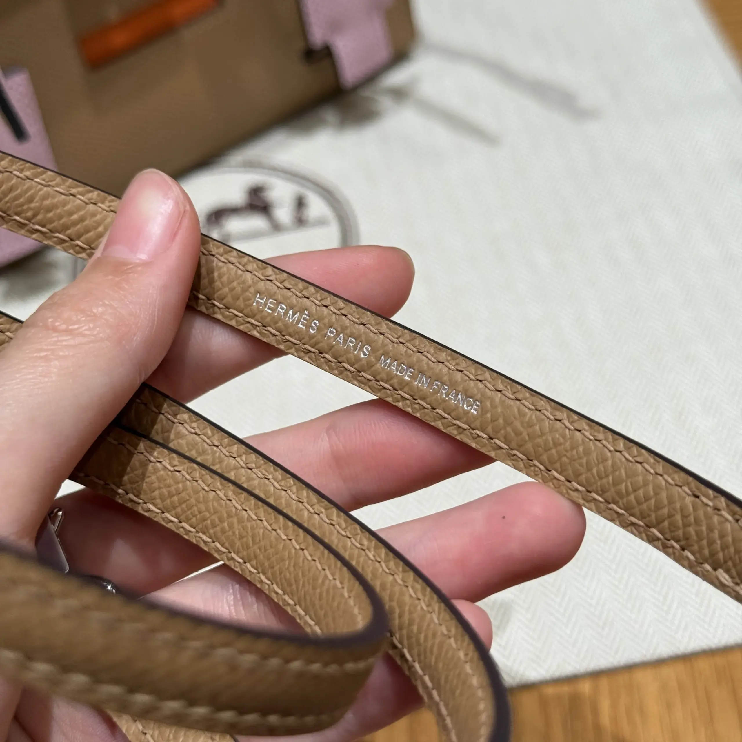 Macro view of the silver foil mark between straight strap stitches