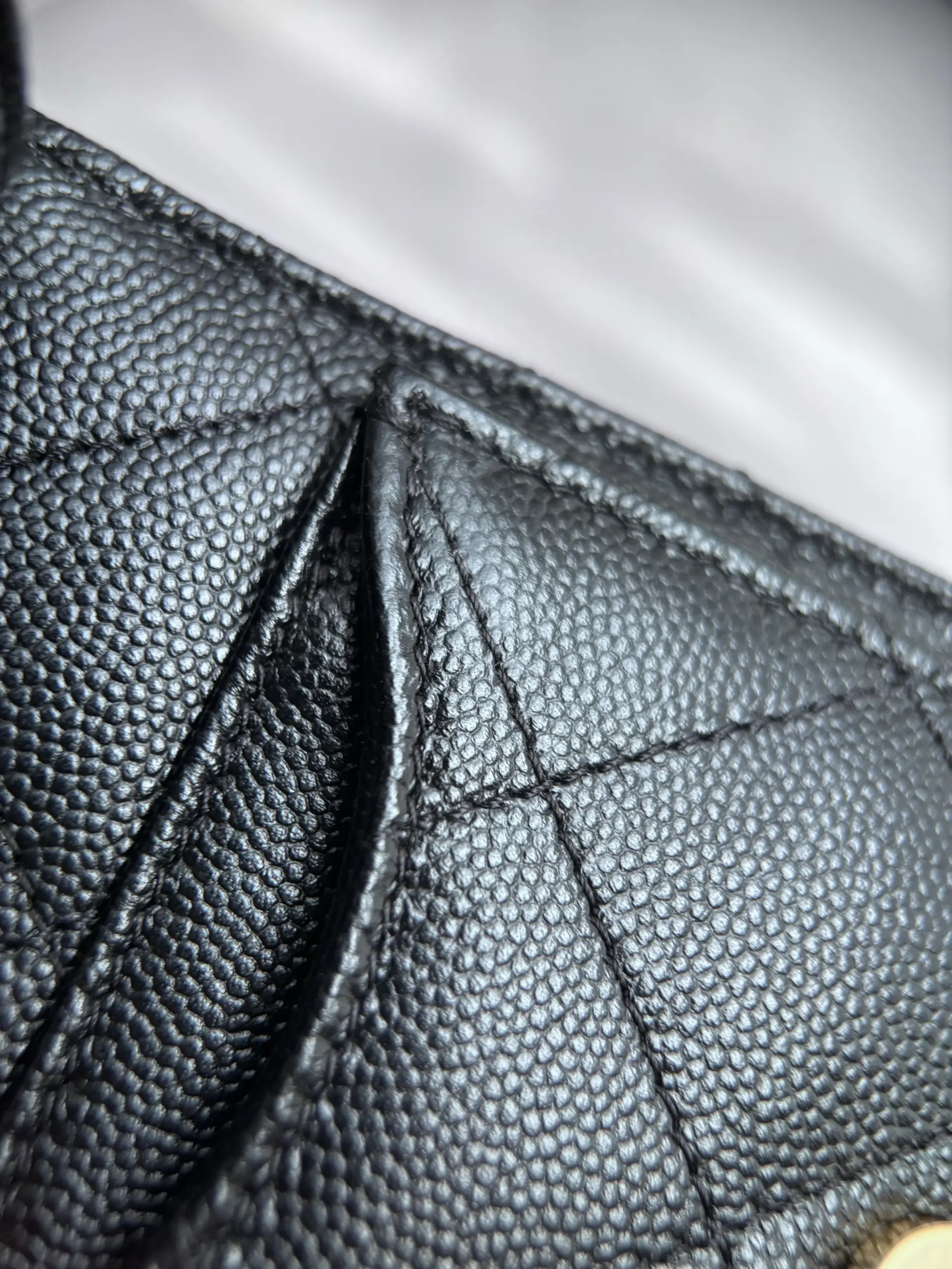 Macro of a folded black caviar gusset corner and stitching