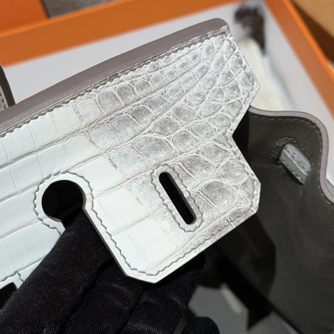 Macro view of a grey flap corner and hand-stitching