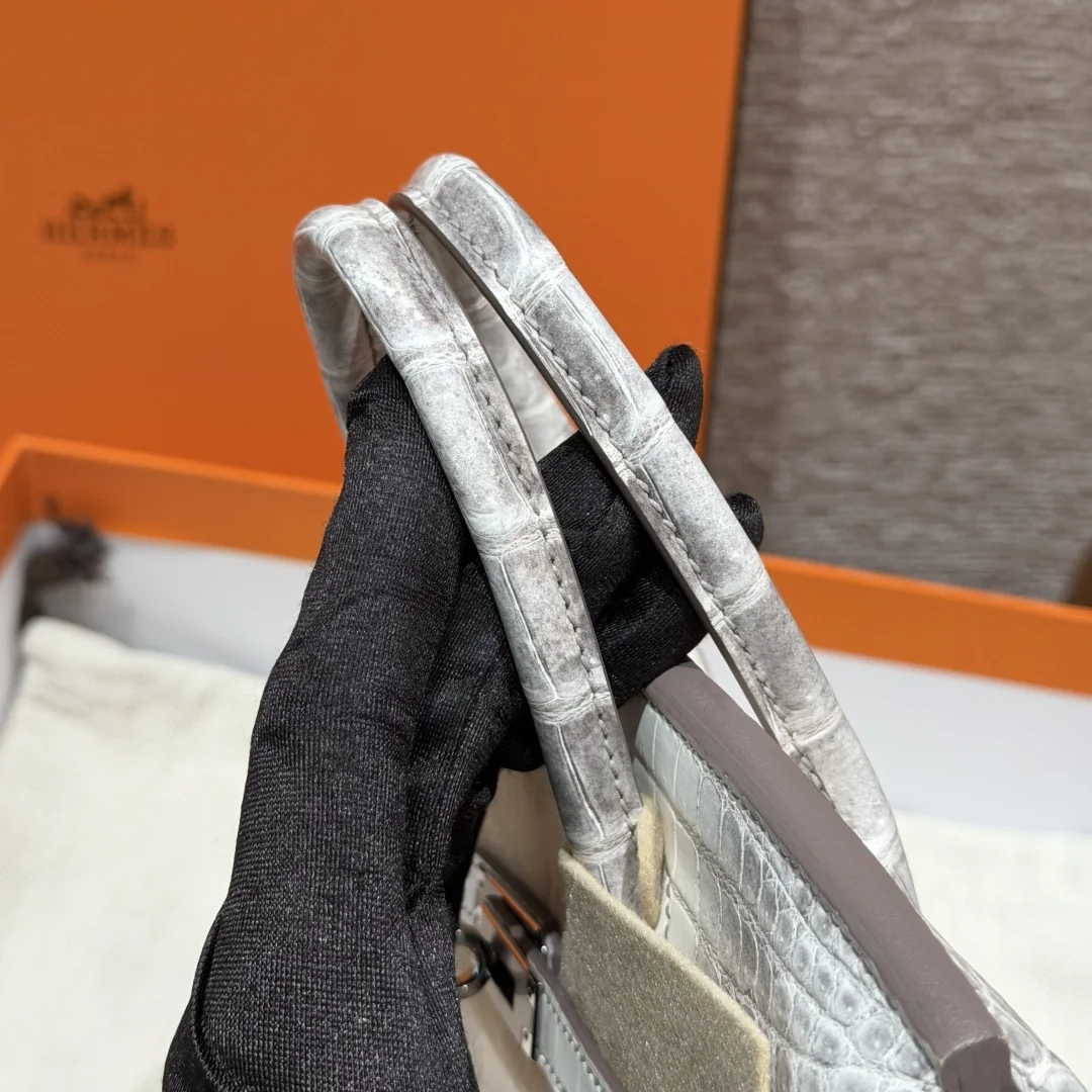 Close view of both rounded top handles and their stitches