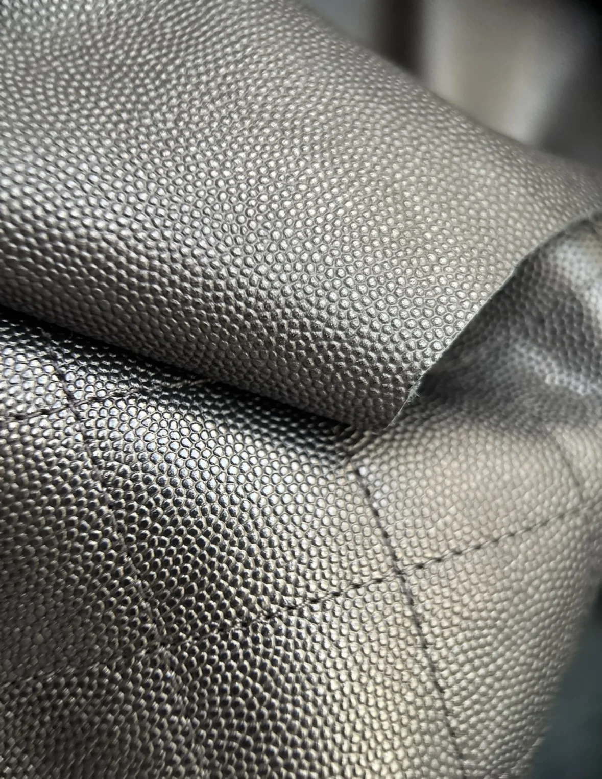 Close material reference of black fine caviar-style leather grain