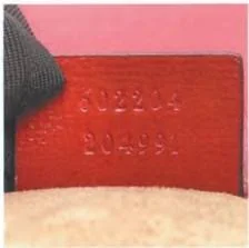 Reverse of a red Gucci leather tag with two stamped number rows