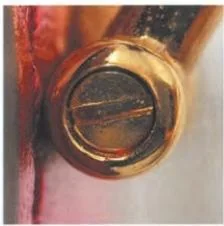 Close-up of a round slotted hardware fitting on a Gucci bag