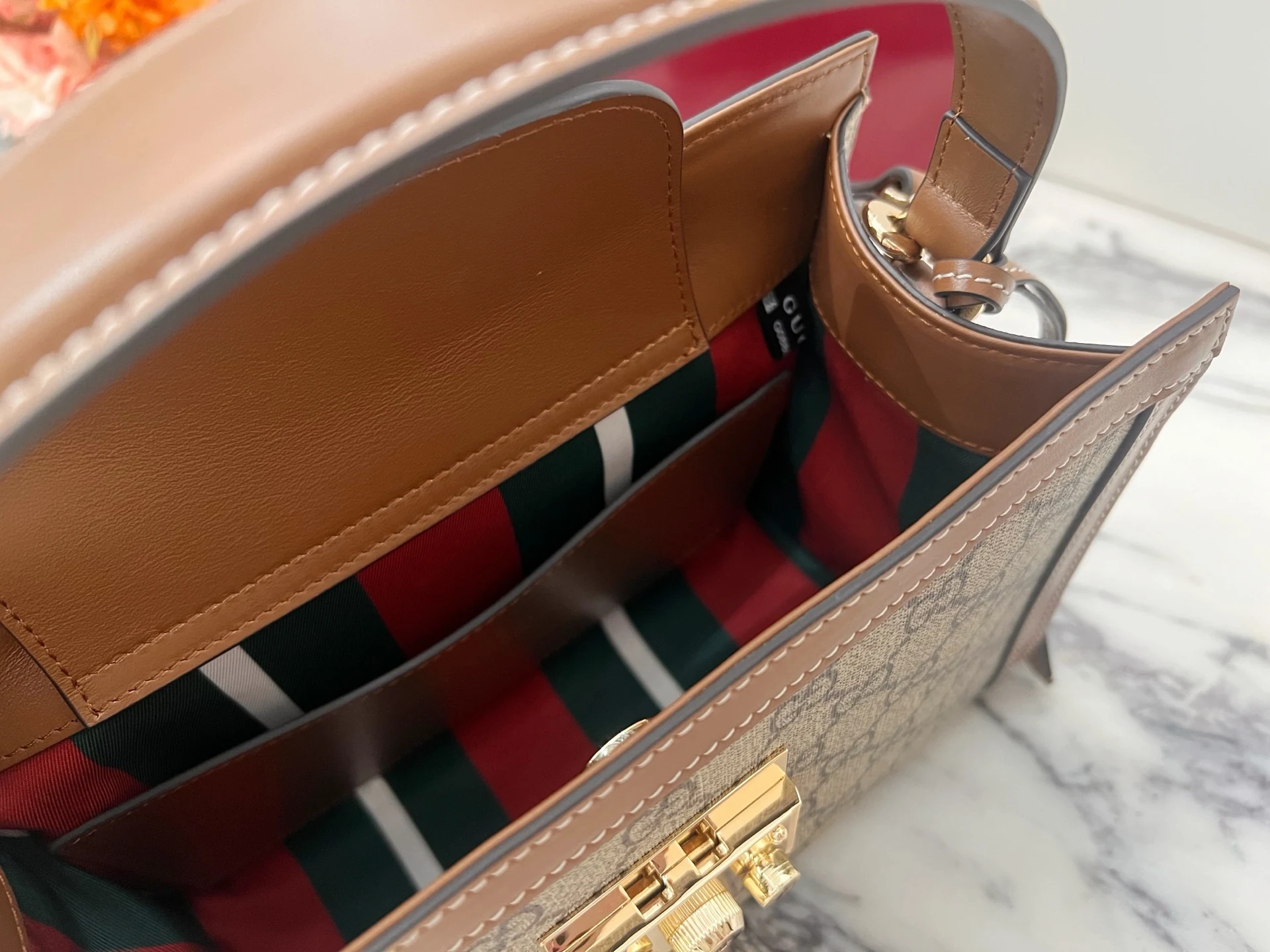 Red, dark green and pale striped lining beneath a brown inner facing