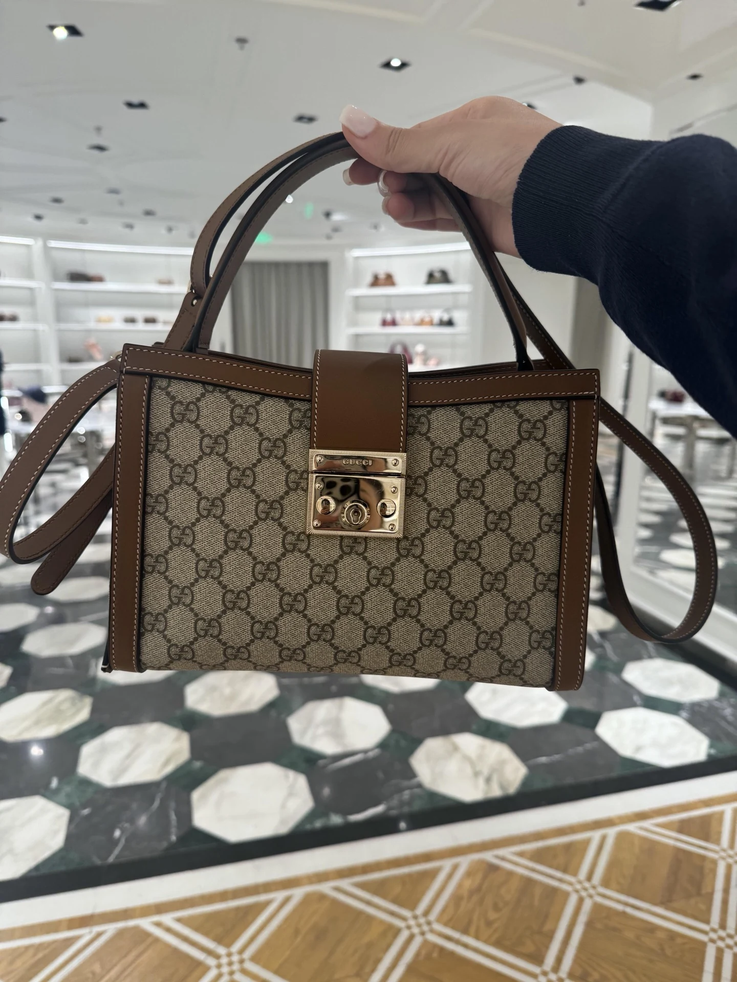 Gucci Padlock suspended by its brown top handle