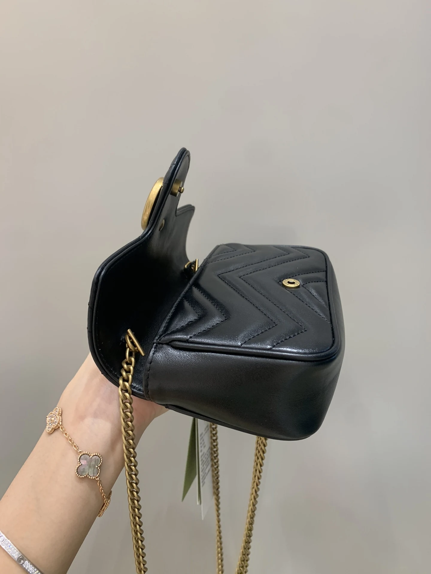 Opposite corner of the open chevron bag with a hanging chain