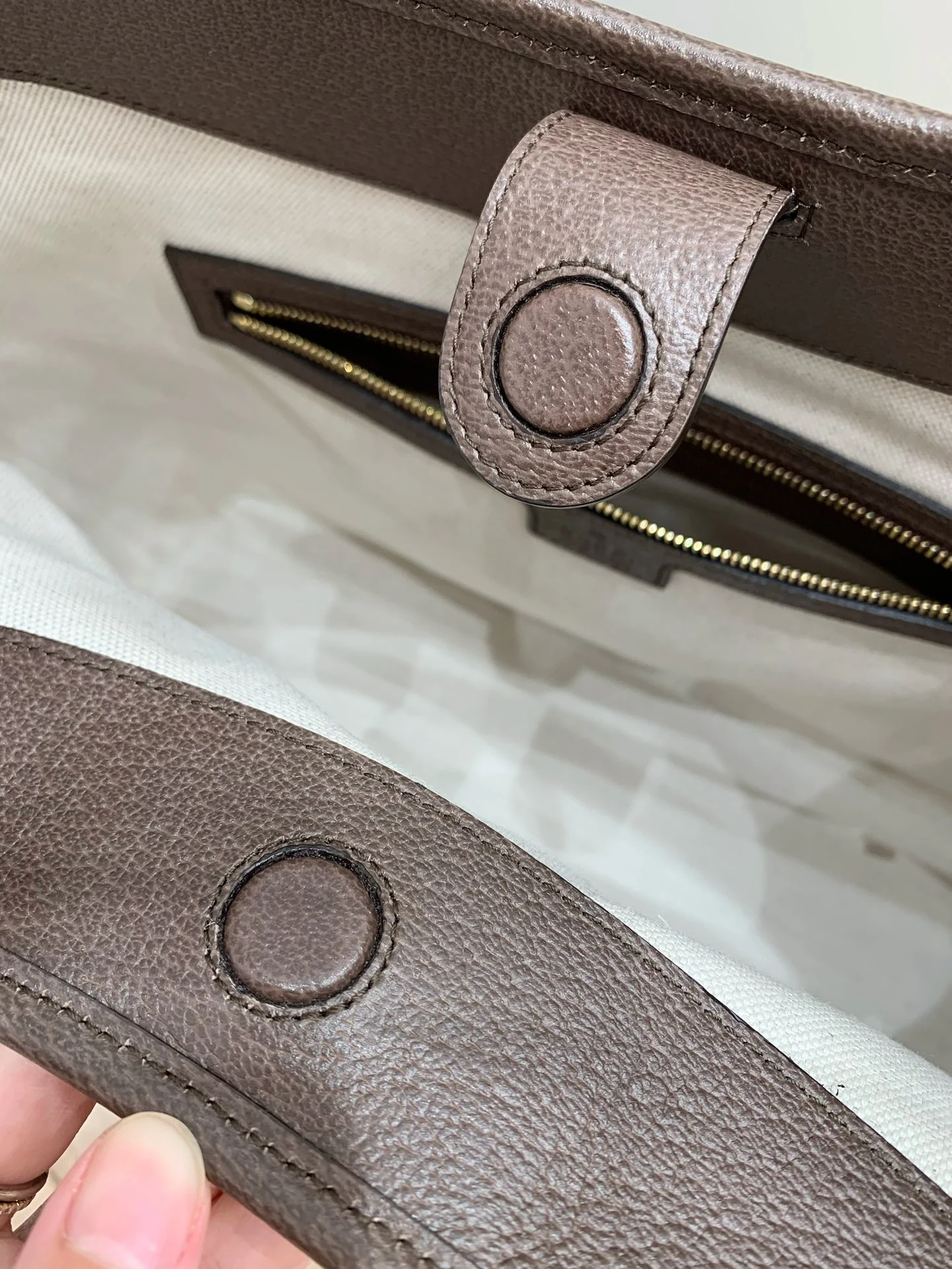 Two brown tabs with round covered magnetic fastenings