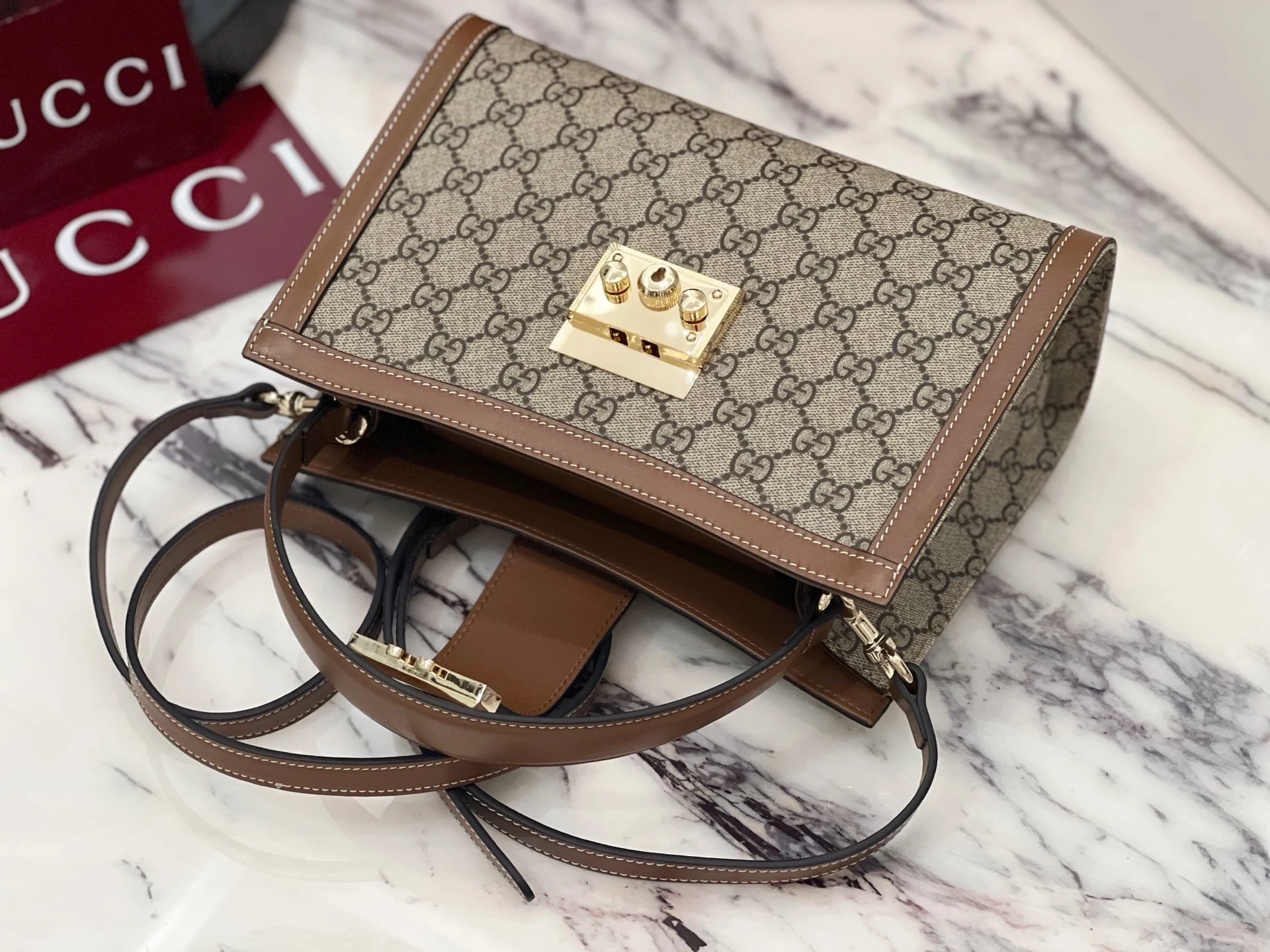 Central fastening released above the bag opening and loose straps