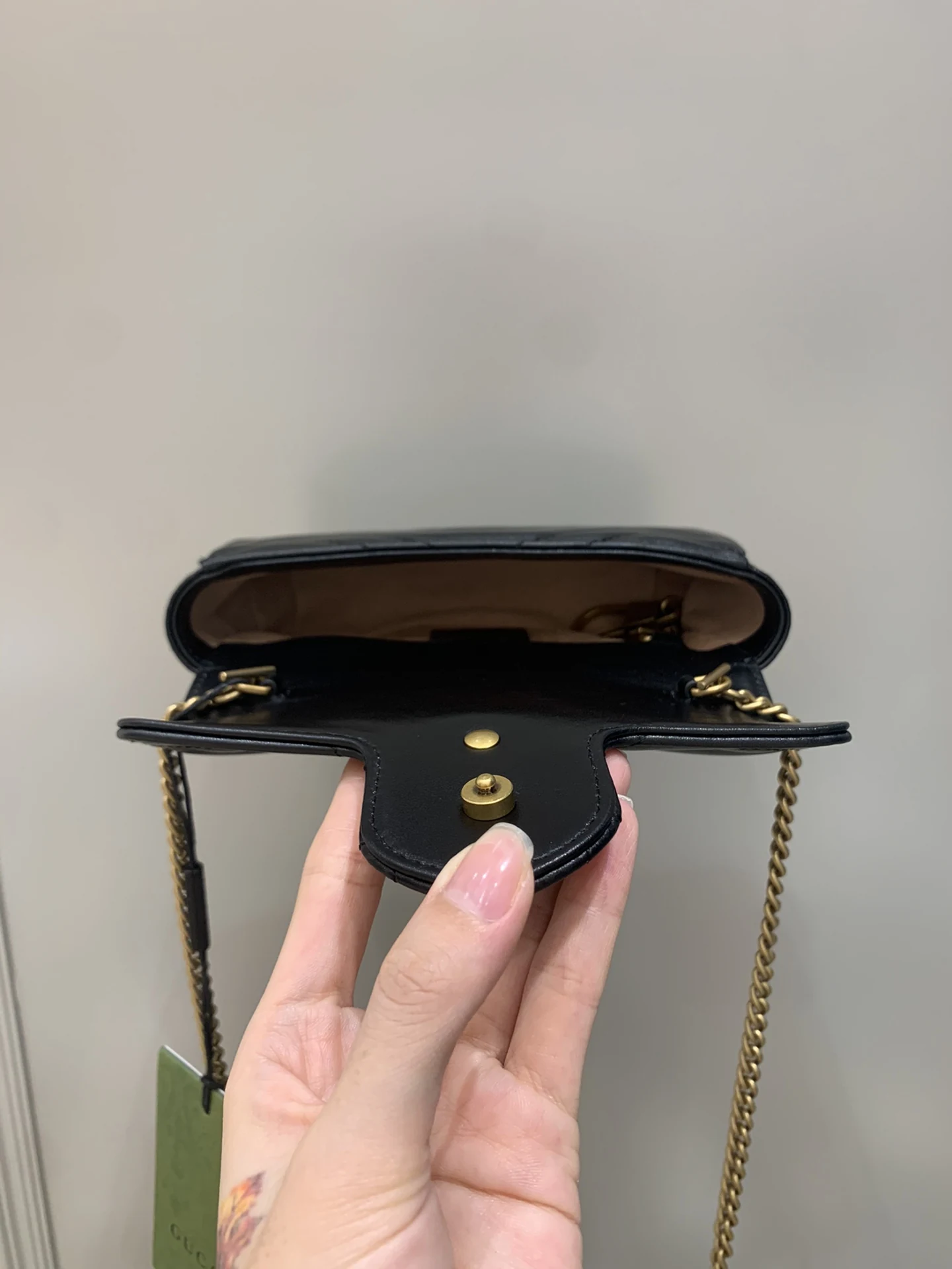 Open mouth of the black bag with light lining and closure fittings