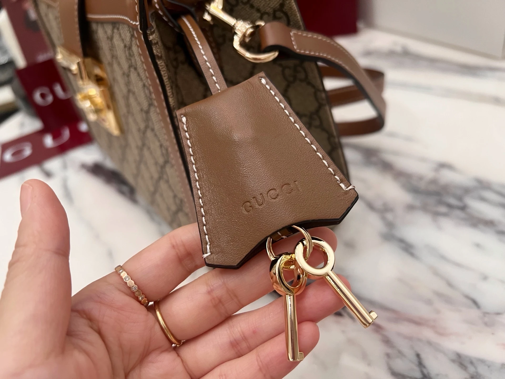 Brown stitched key holder with two gold-tone keys