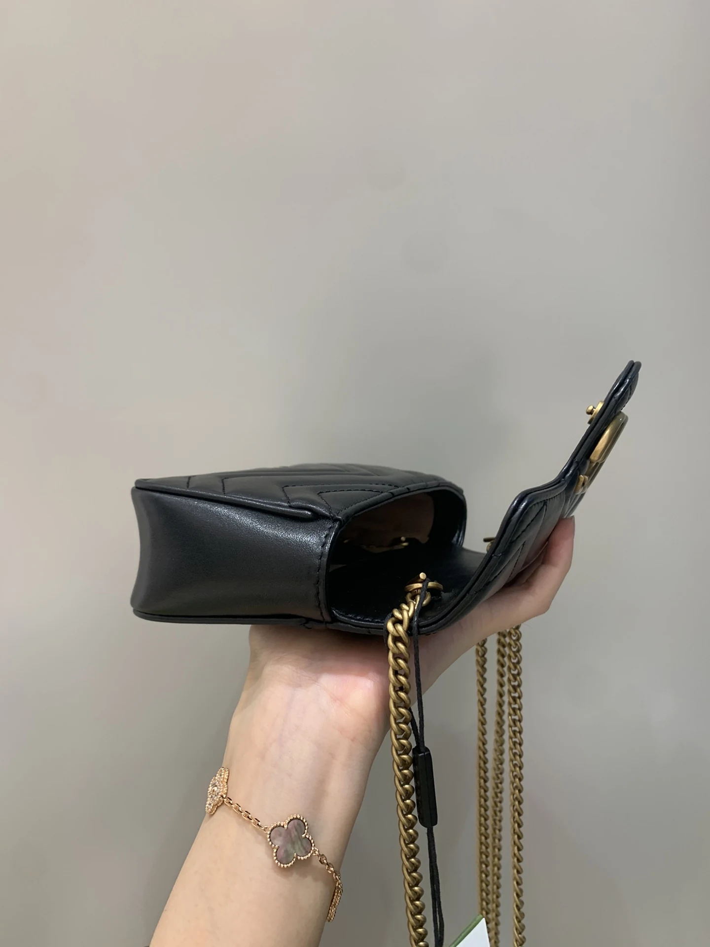 Side profile of the open bag with the flap lifted and chain hanging