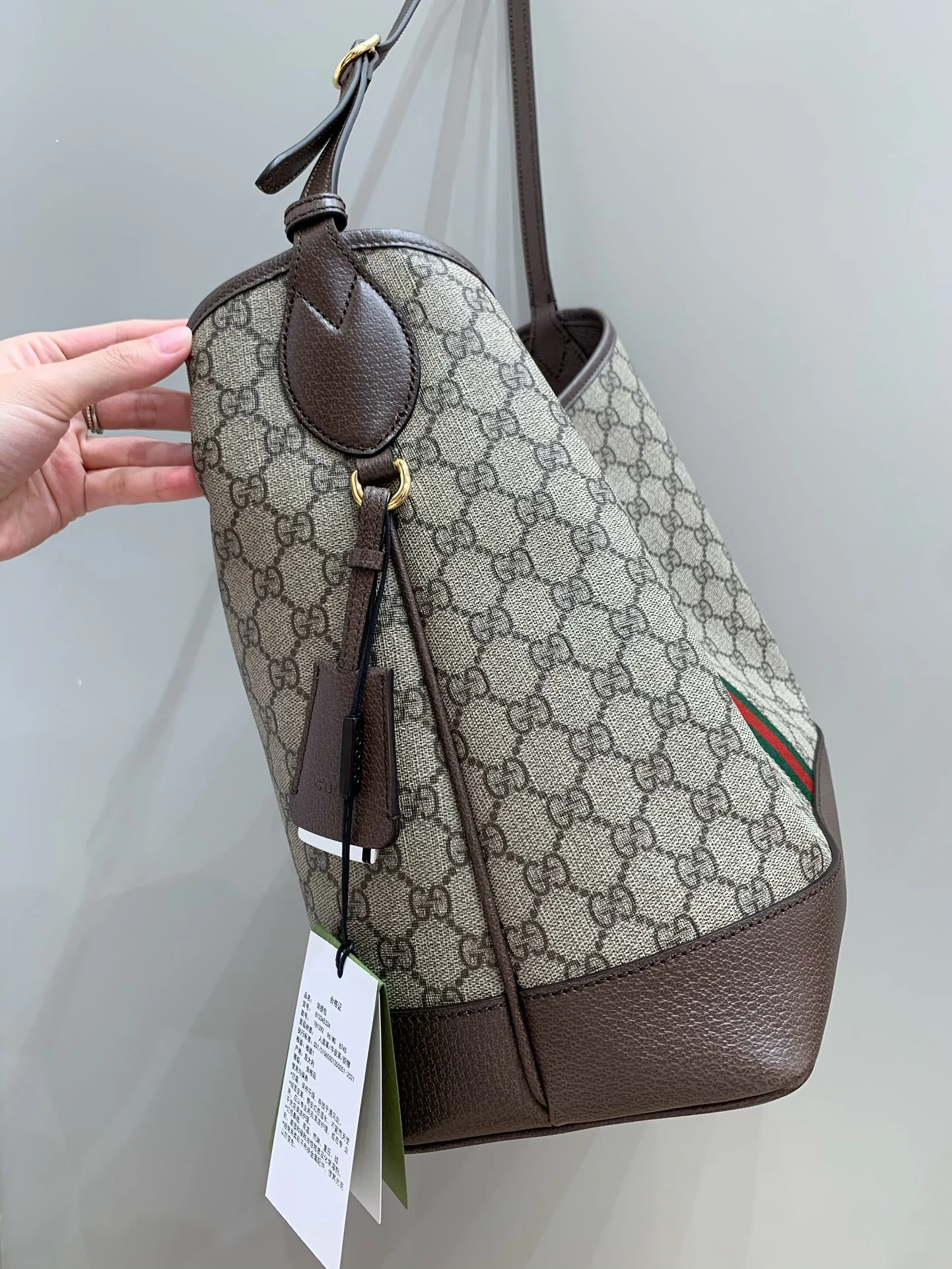 Rounded brown strap attachment above a side seam and mirror holder